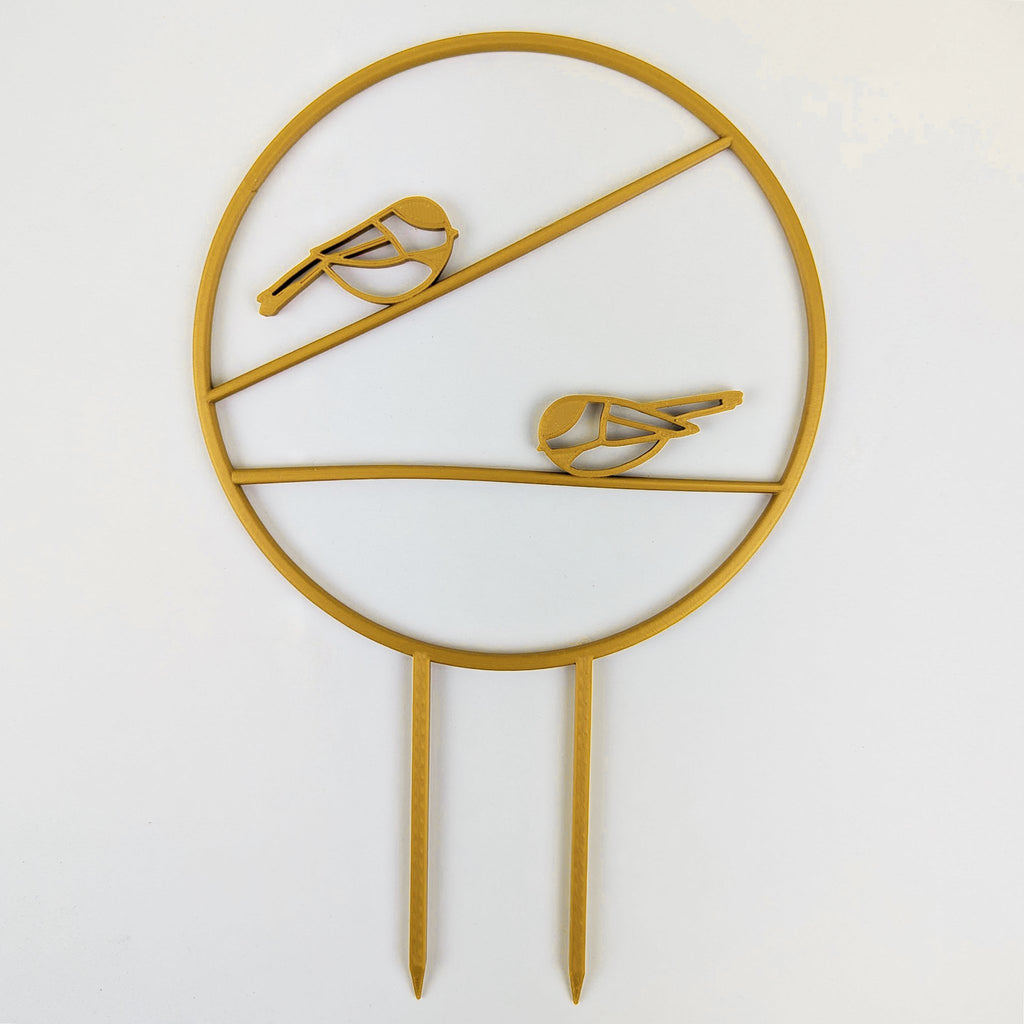 Chickadee trellis in gold, a circle with two chickadees on horizontal branches