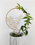 Wood hummingbird trellis with a hoya vine wrapped around the circle