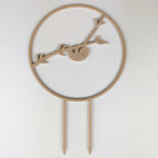 Sloth circle trellis in a wood finish, a sloth hanging from a branch inside the circle