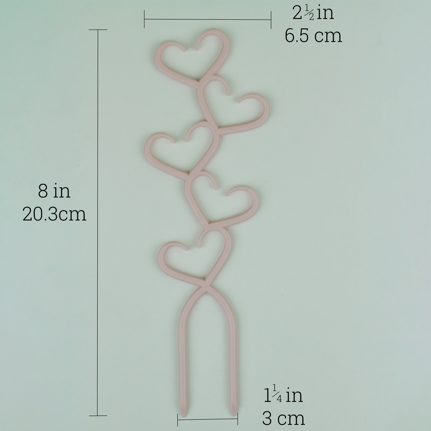 A pastil pink stacked hearts trellis against a white background and showing the trellis dimensions, 8 inches by 2.5 inches.