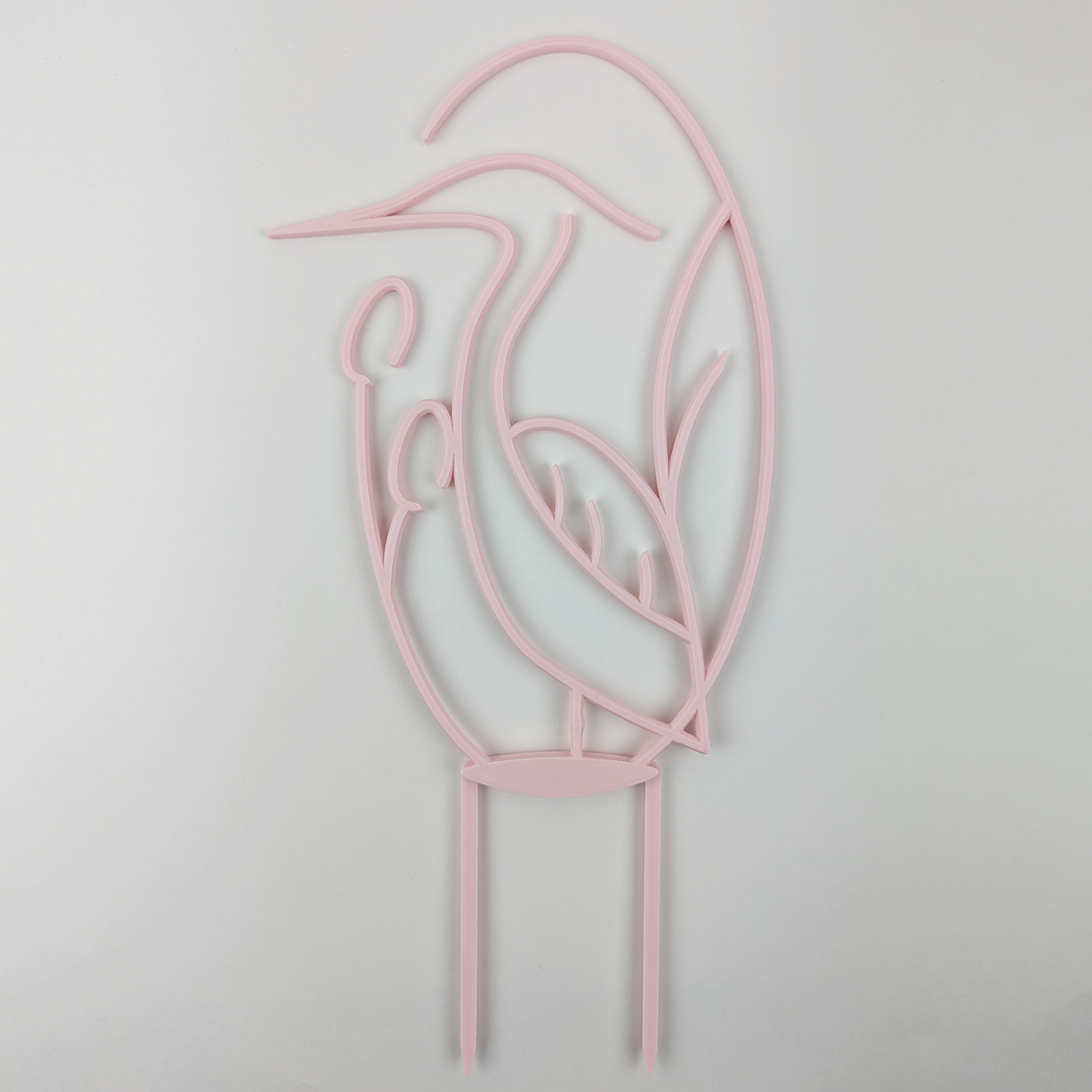 Houseplant trellis in the shape of a heron, in pastel pink color against a plain white background.