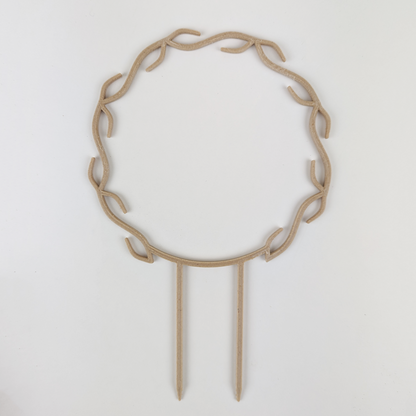 A wreath trellis. It has little hooks that go around in a circle, almost looking like a wreath. It is in wood colour against a white background.